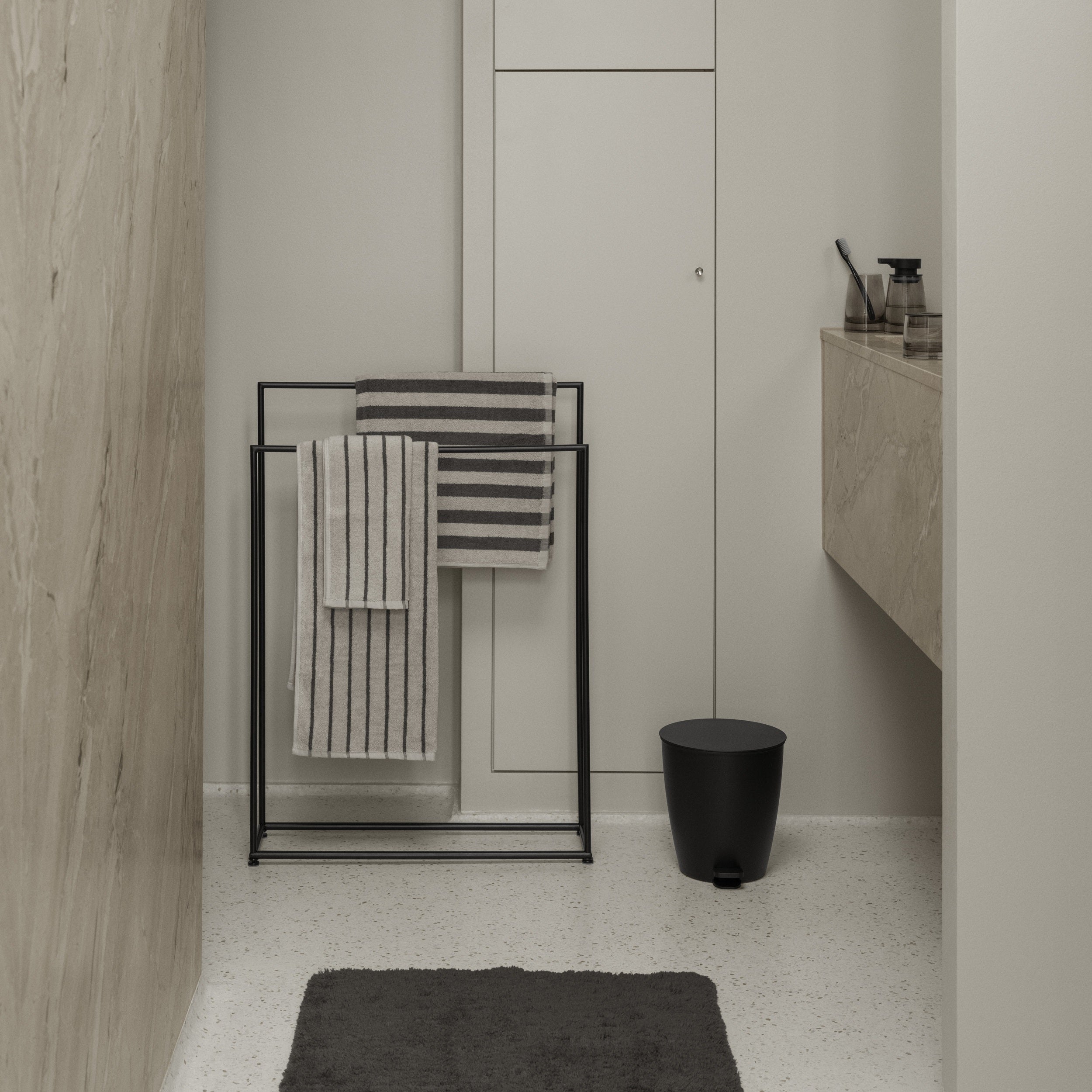 Bathroom interior with towel rack, toilet, and sink.