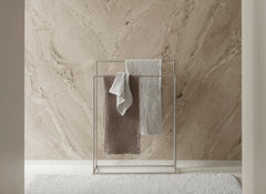 Towel rack with towels against a marble wall
