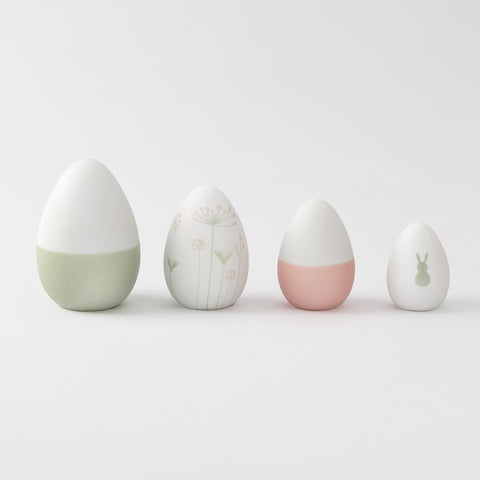 R17462 Four porcelain Easter decorative eggs with different designs on a light gray background