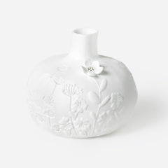 Porcelain Stories White porcelain vase with floral patterns on a white background.